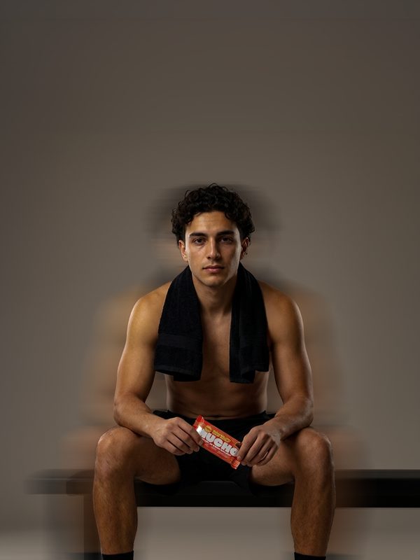 Creator on a gym bench holding a Mucho bar